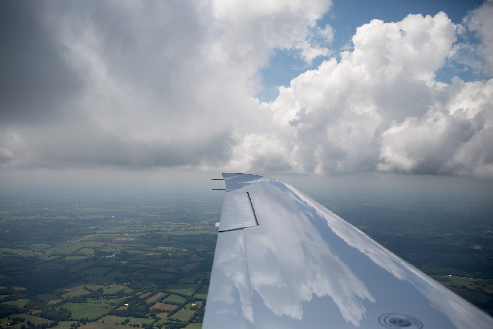 A Cirrus wing above towering clouds at altitude