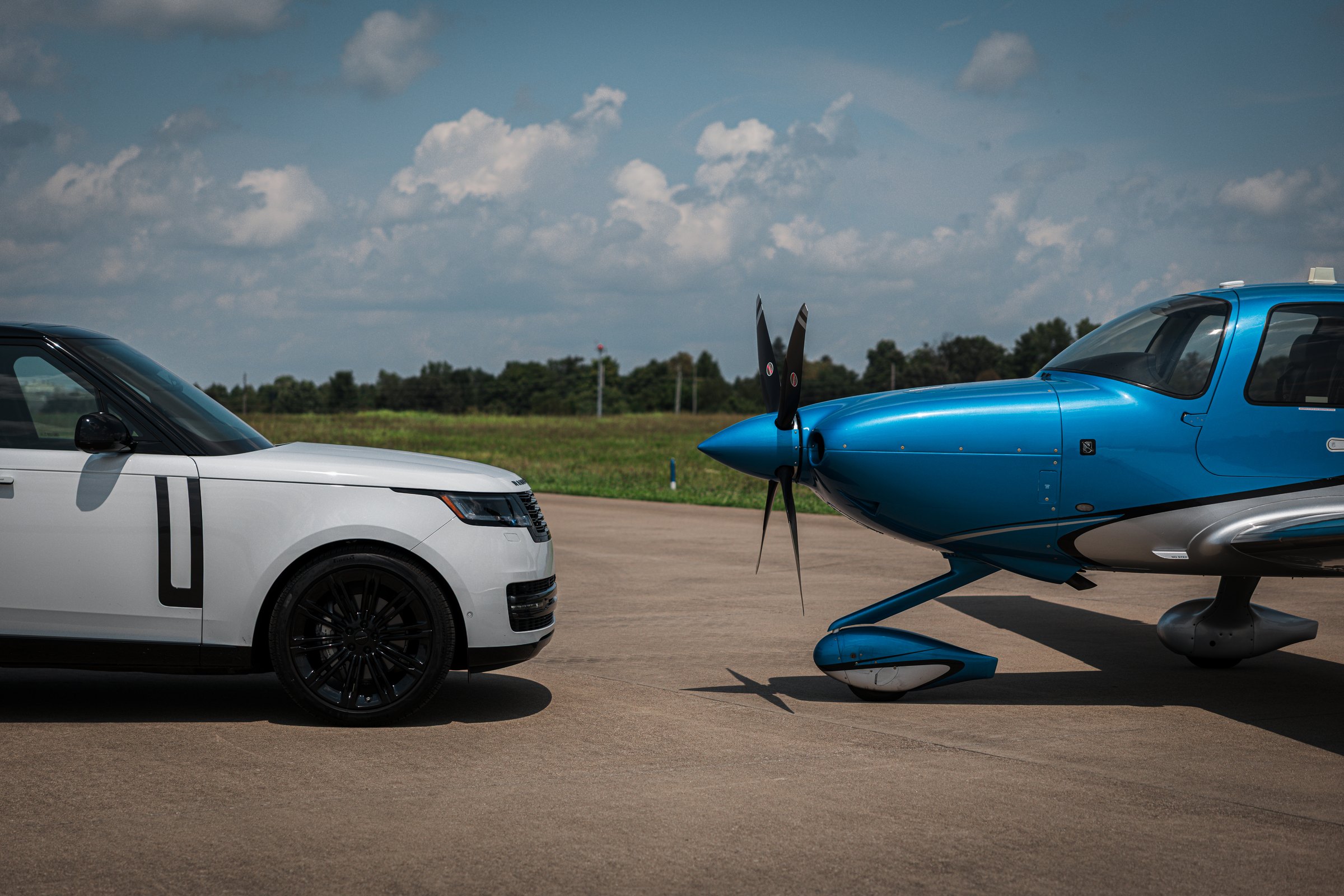 A Range Rover parked beside a Cirrus SR on the ramp