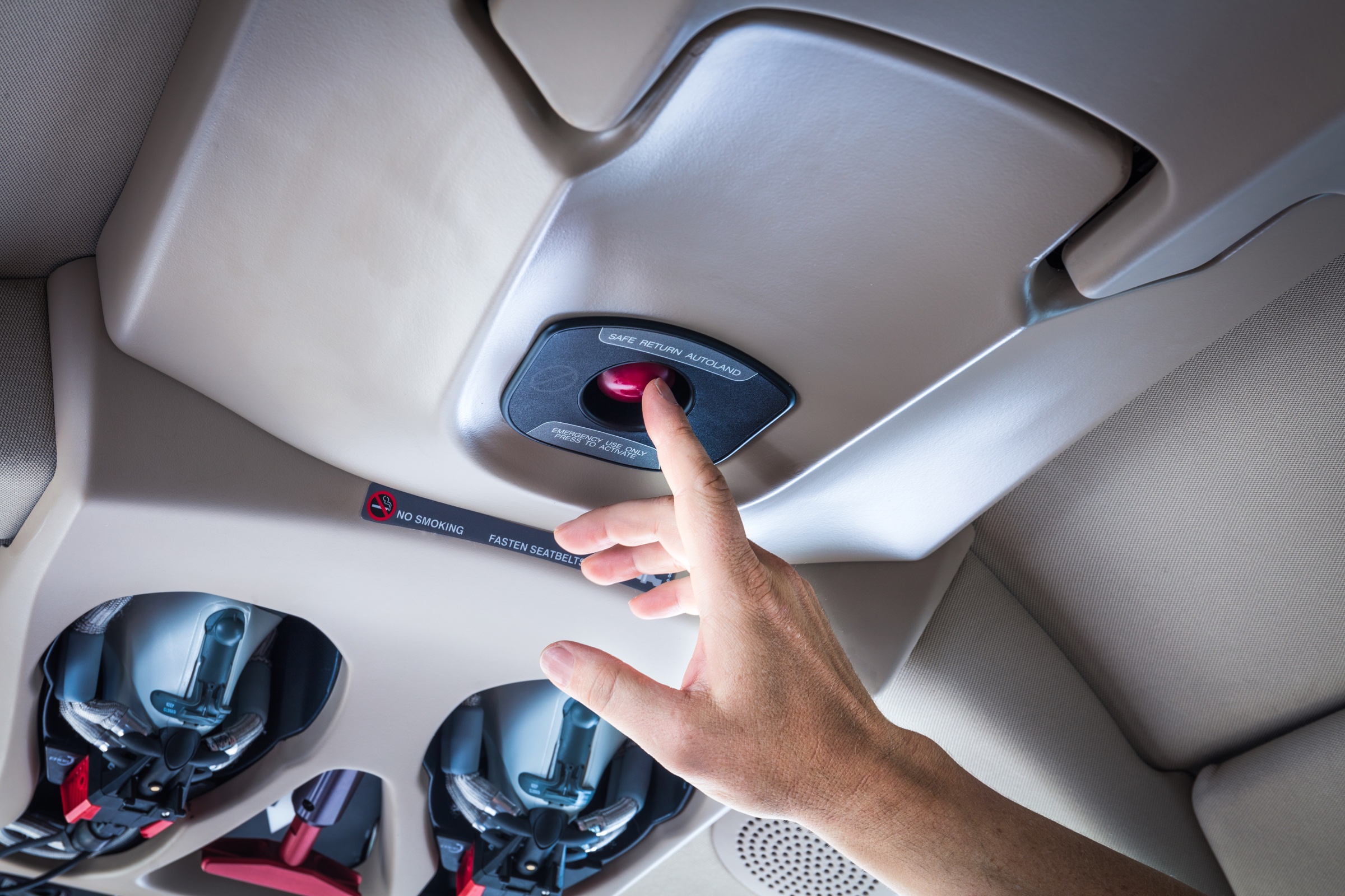 Hand pressing Safe Return button in Vision Jet cabin